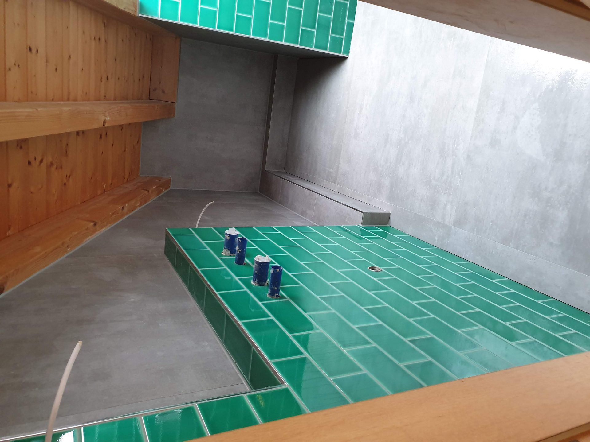Gefliestes Podest mit grünen Metro-Fliesen und großformatigen grauen Fliesen in Betonoptik auf einer Fliesenbaustelle im Dachgeschoss in Dillingen