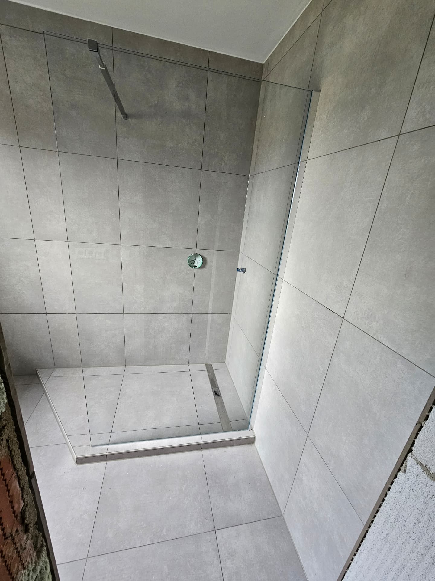 Fertig saniertes, graues Duschbad mit bodengleicher Dusche nach einer Badsanierung
